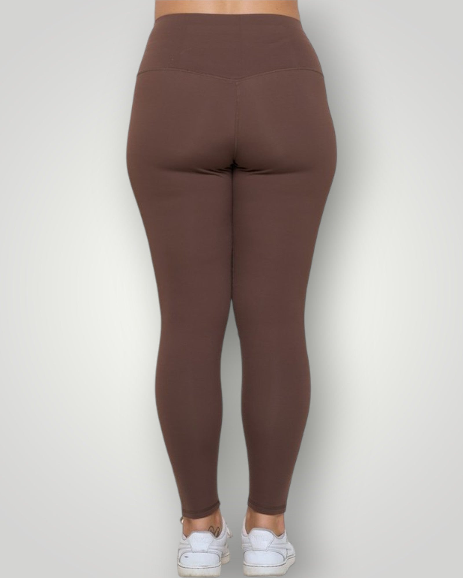 Brown leggings worn by a person on a white background