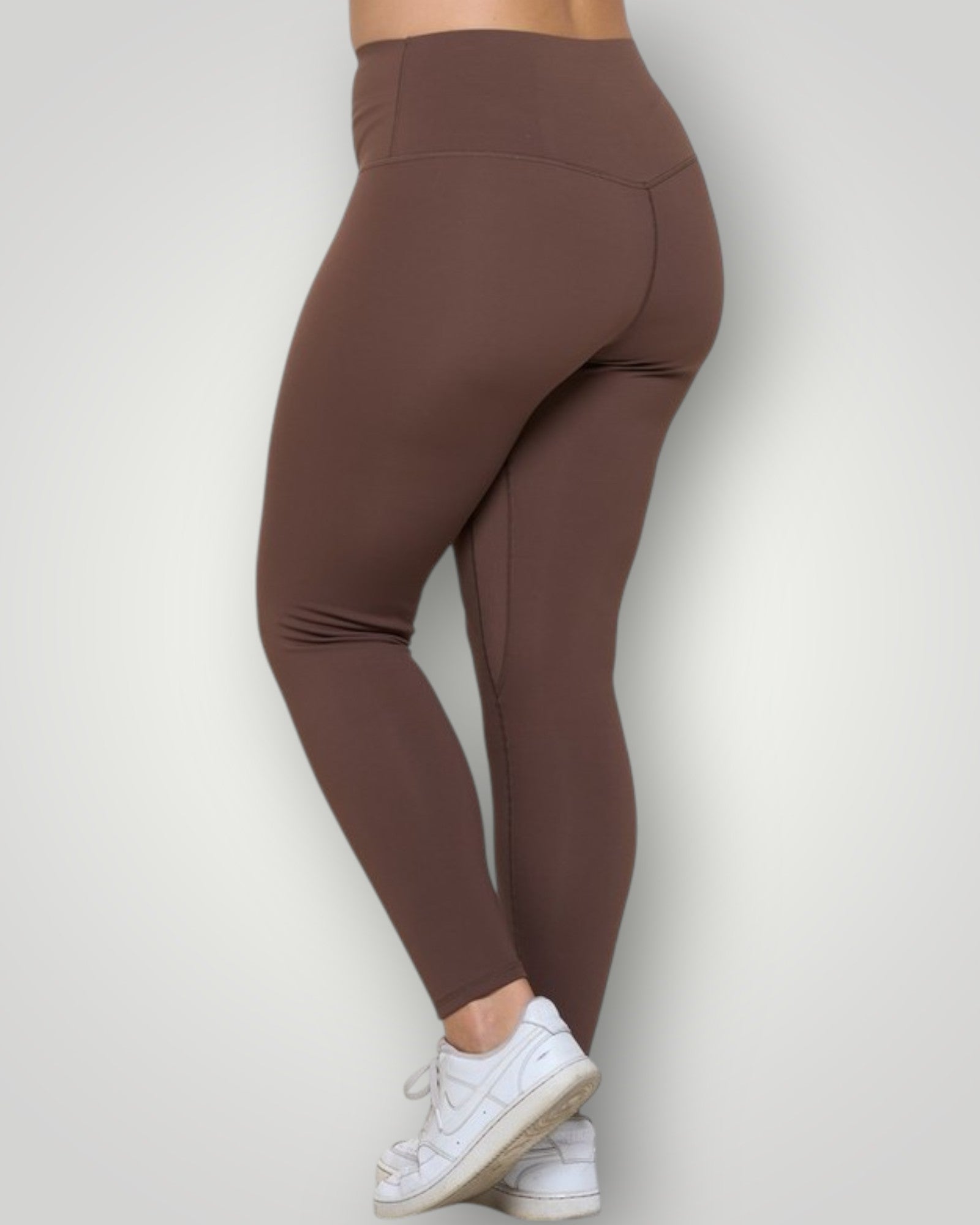 Brown leggings worn by a person on a white background