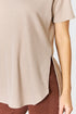 Beige ribbed sweater with a side slit worn by a person on a white background