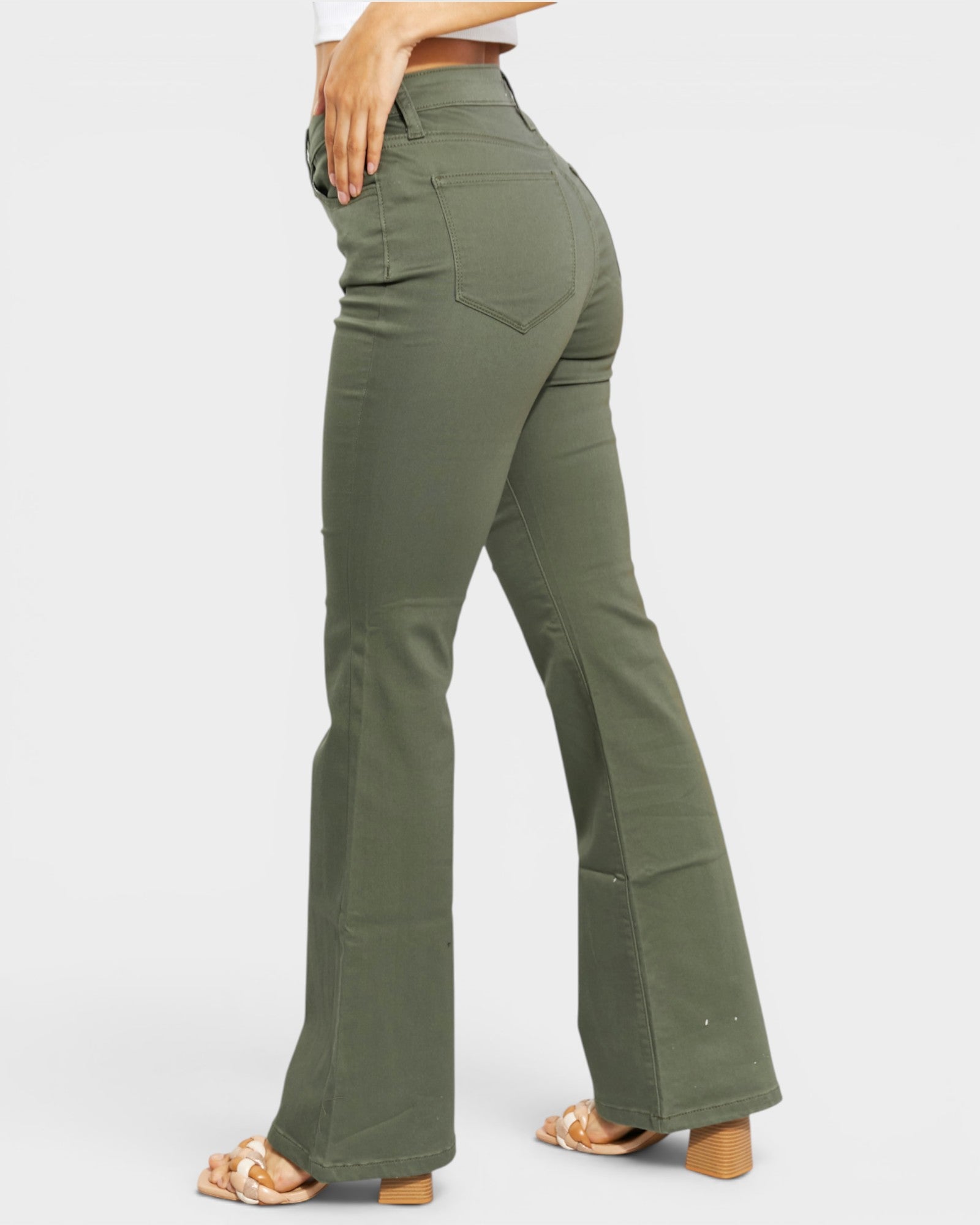 Green flared pants worn by a person on a white background