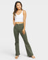 Woman wearing green pants and a white top on a white background