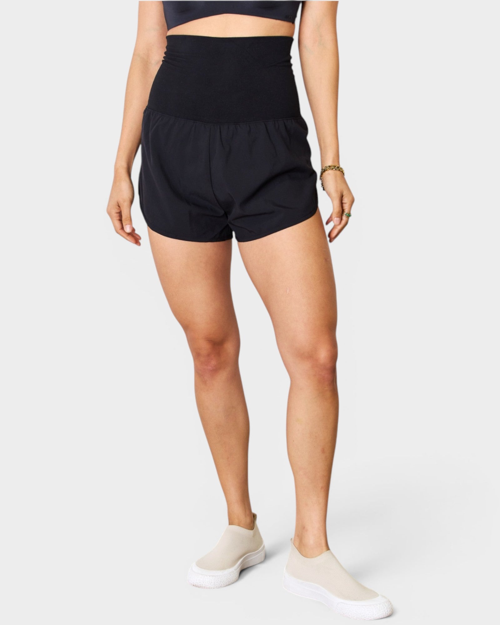 Person wearing black shorts on a white background