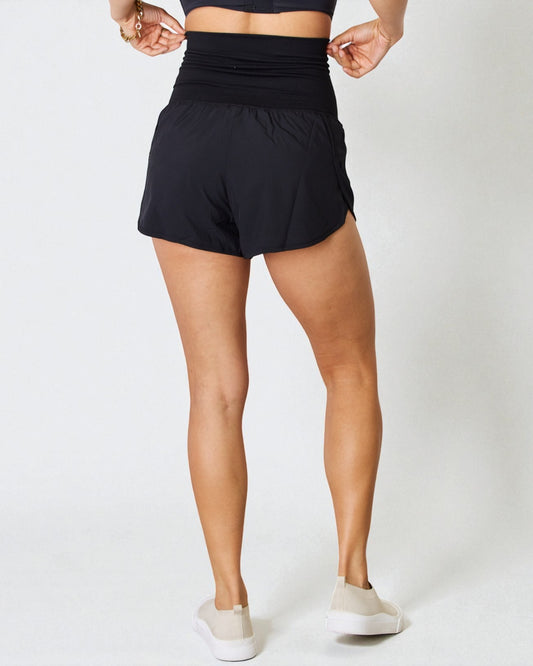 Person wearing black athletic shorts on a white background