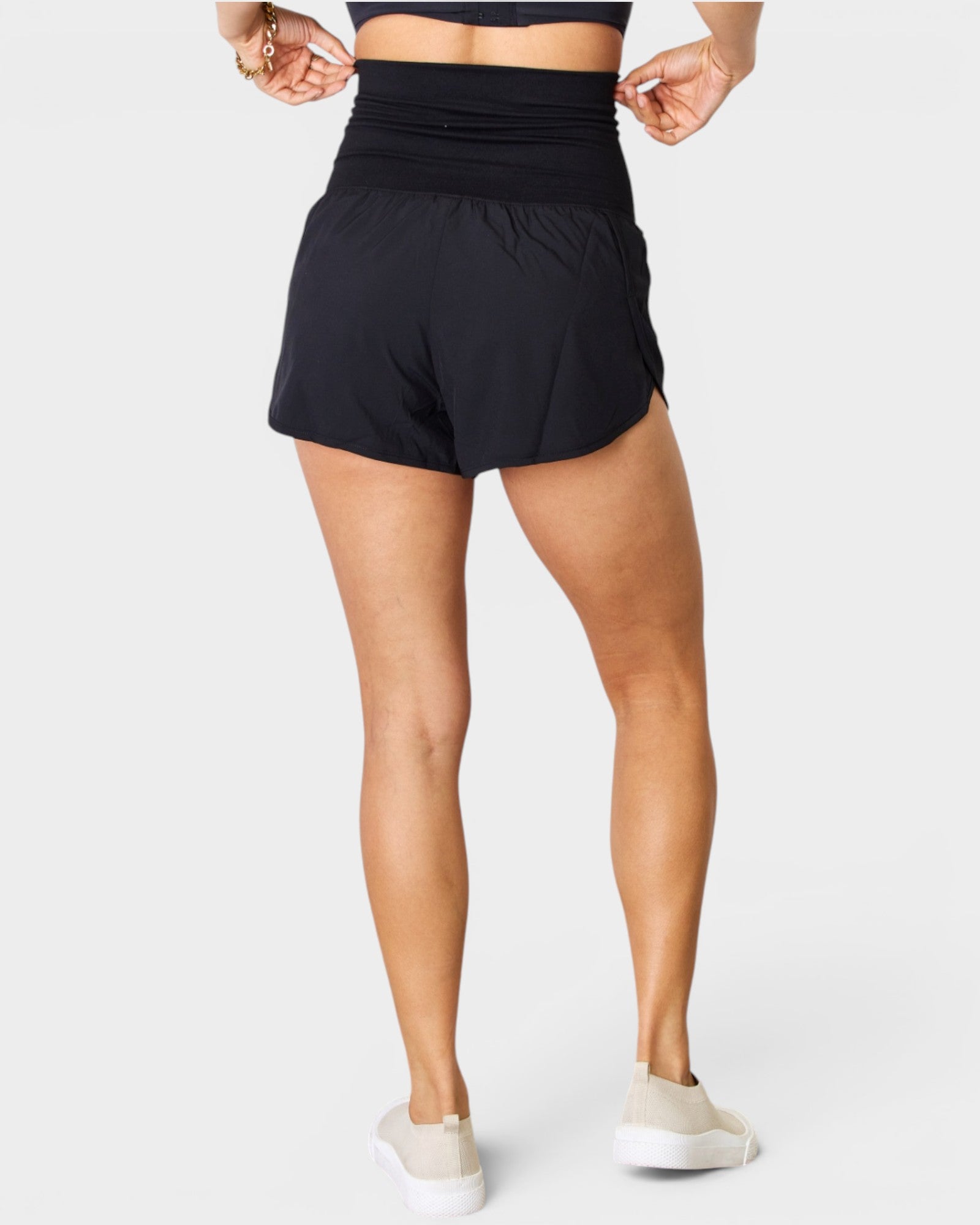 Person wearing black athletic shorts on a white background