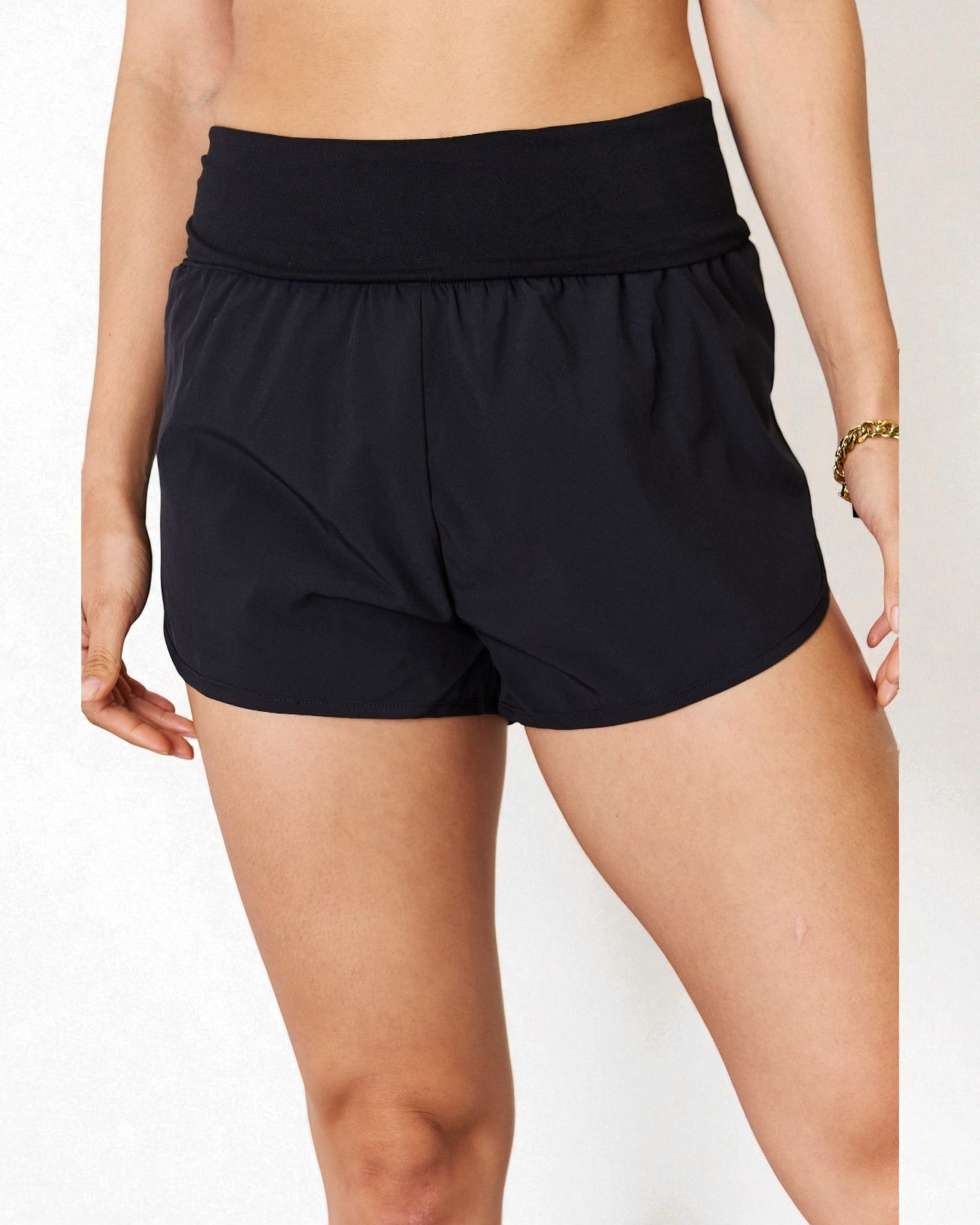 Black shorts worn by a person on a white background