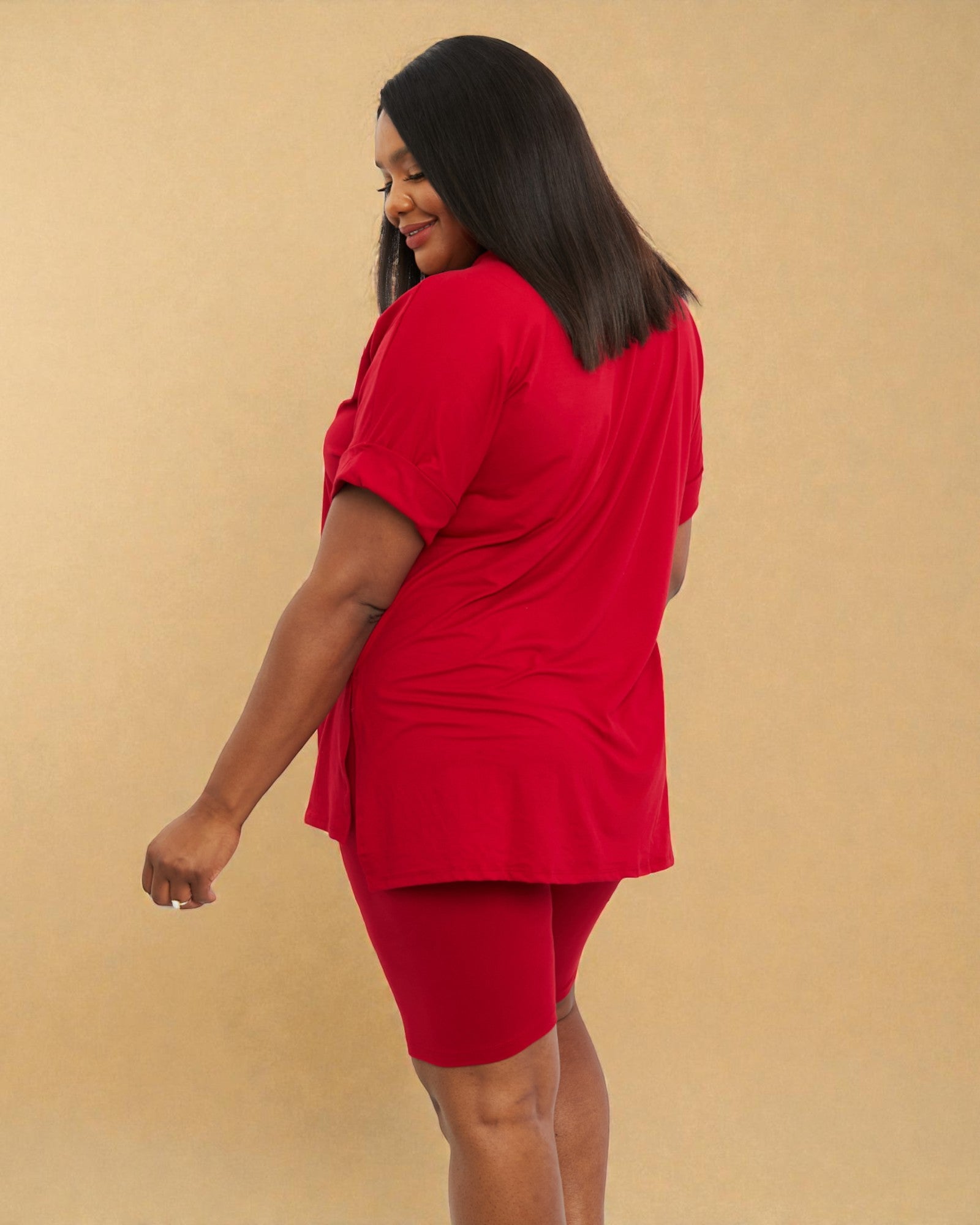 Woman wearing a red outfit against a beige background