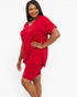 A woman modeling a bright red two-piece lounge set consisting of a short-sleeve V-neck top and matching fitted shorts, photographed against a clean white studio background.