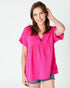Woman wearing a bright pink blouse on a white background