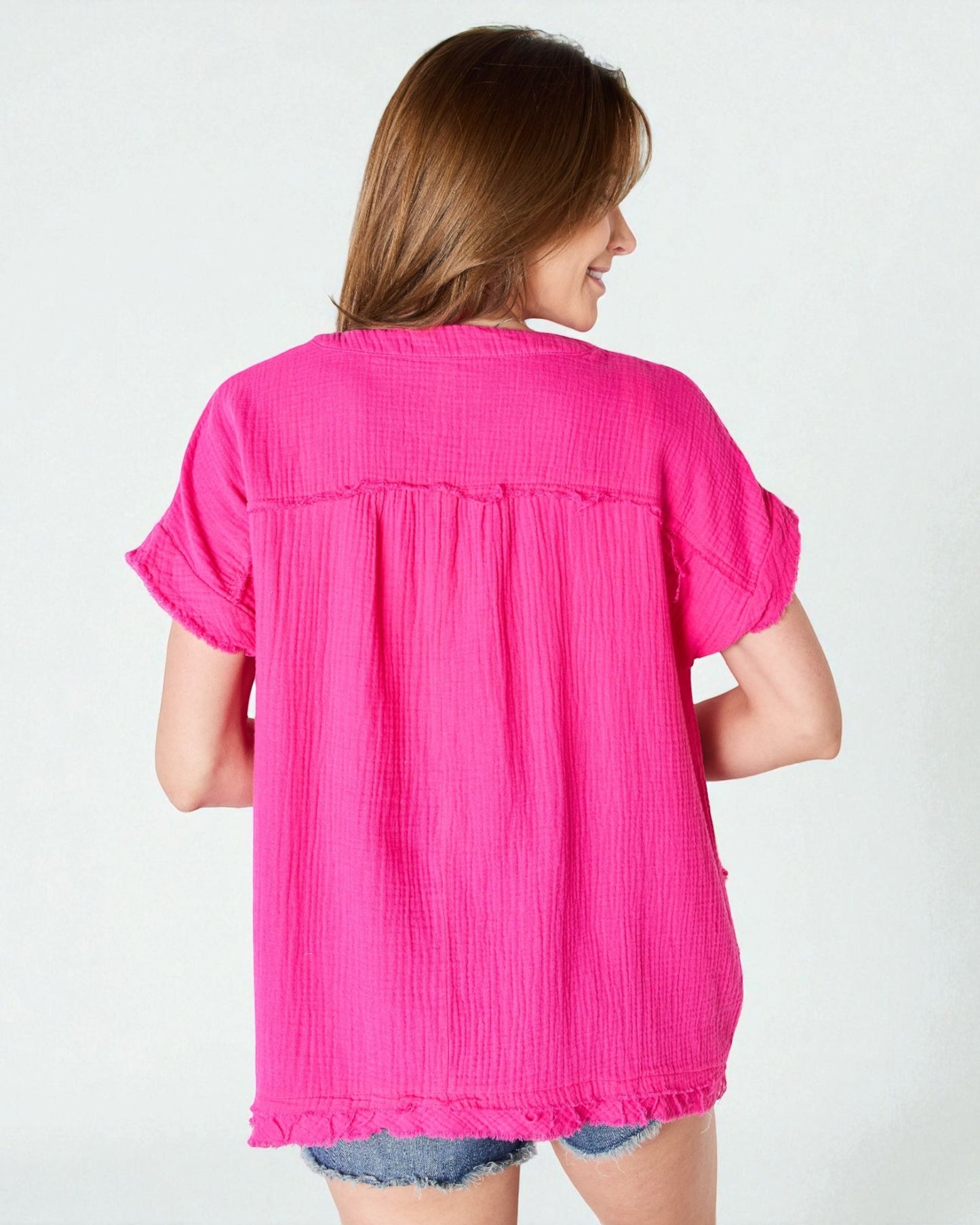 Woman wearing a bright pink blouse on a white background