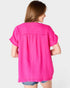 Woman wearing a bright pink blouse on a plain background