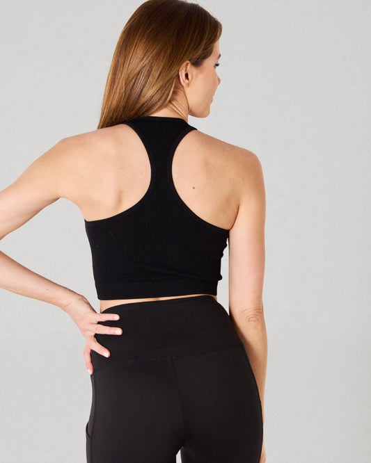 Woman wearing a black athletic outfit on a gray background