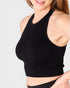 Black ribbed crop top worn by a person on a light gray background