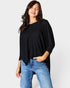 Woman wearing a black sweater and blue jeans on a white background