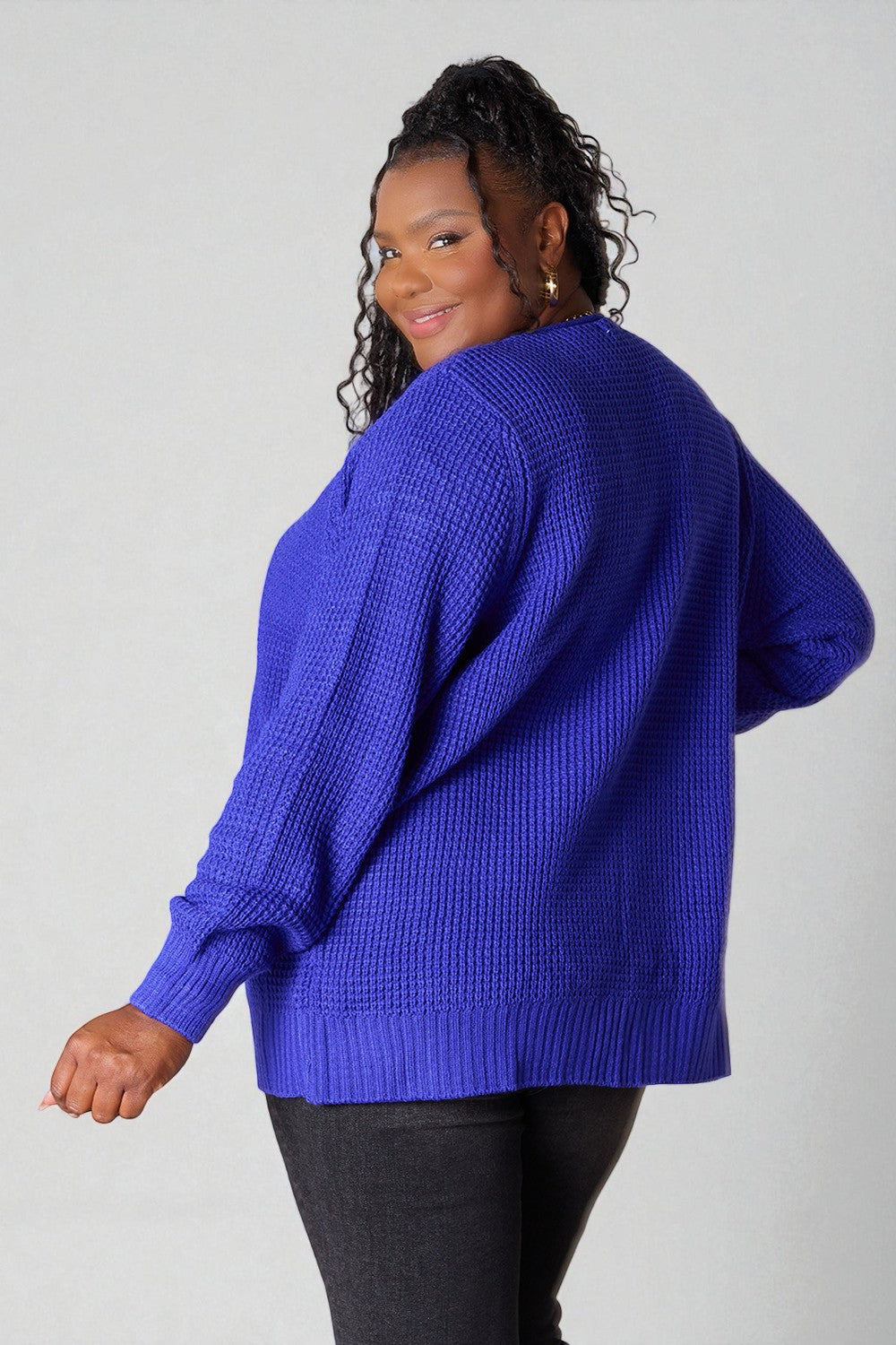 Person wearing a blue sweater on a plain background