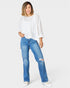 Woman wearing a white top and blue jeans on a white background