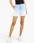 A model wearing light blue and white gradient drawstring shorts, paired with a black top and white sneakers, against a plain white background.