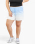 A person wearing light blue and white gradient athletic shorts with a drawstring waist, paired with a black cropped top and gray sneakers, against a plain light background.