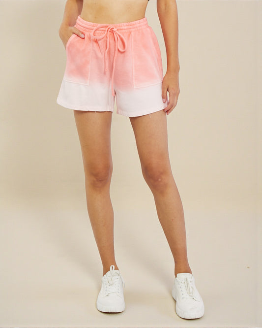 Person wearing pink and white gradient shorts on a beige background