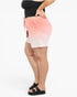 A person wearing a coral pink and white ombre gradient drawstring shorts, paired with a black crop top and black slide sandals, shown from the waist down against a white studio background.