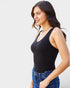 Woman wearing a black tank top and blue jeans on a white background