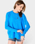 Woman wearing a blue sweater and denim shorts on a white background