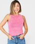 Woman wearing a pink ribbed tank top and blue jeans on a white background