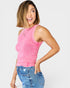 Woman wearing a pink sleeveless top and blue jeans on a white background