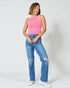 Woman wearing a pink sleeveless top and blue jeans on a white background