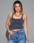 Woman wearing a blue ribbed tank top and jeans against a gray background
