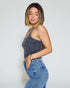 Woman wearing a denim top and jeans against a plain background