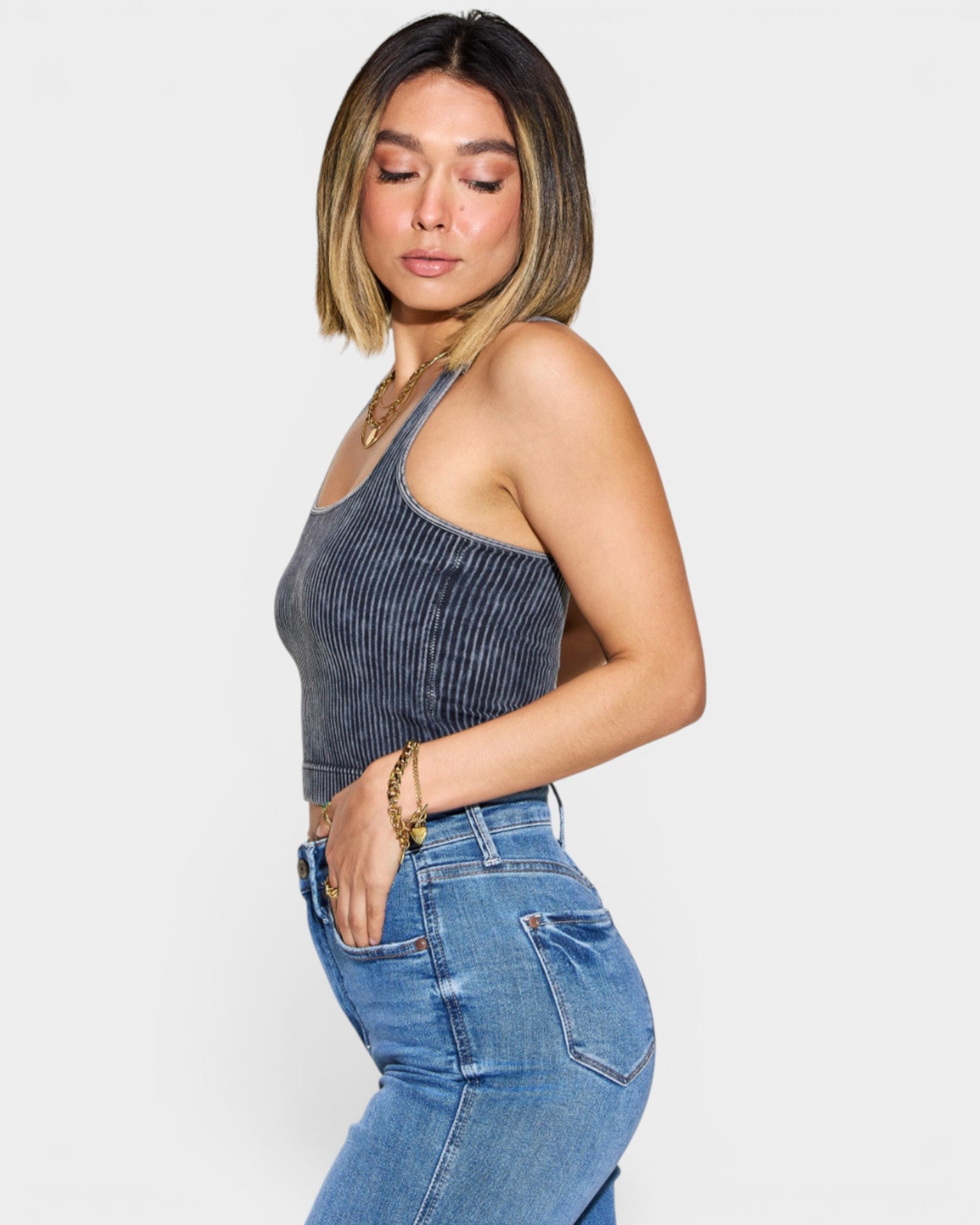 Woman wearing a denim tank top and jeans on a white background