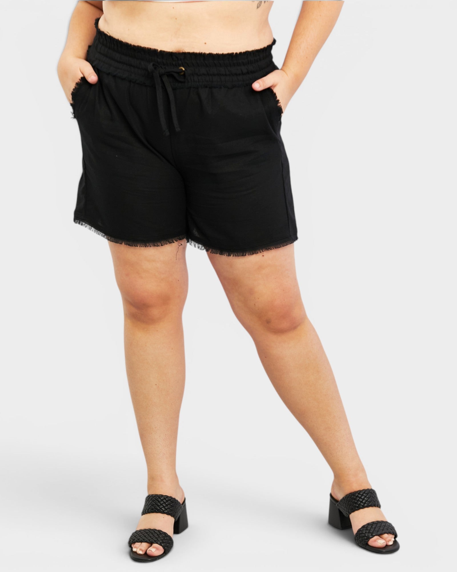 Person wearing black shorts on a white background