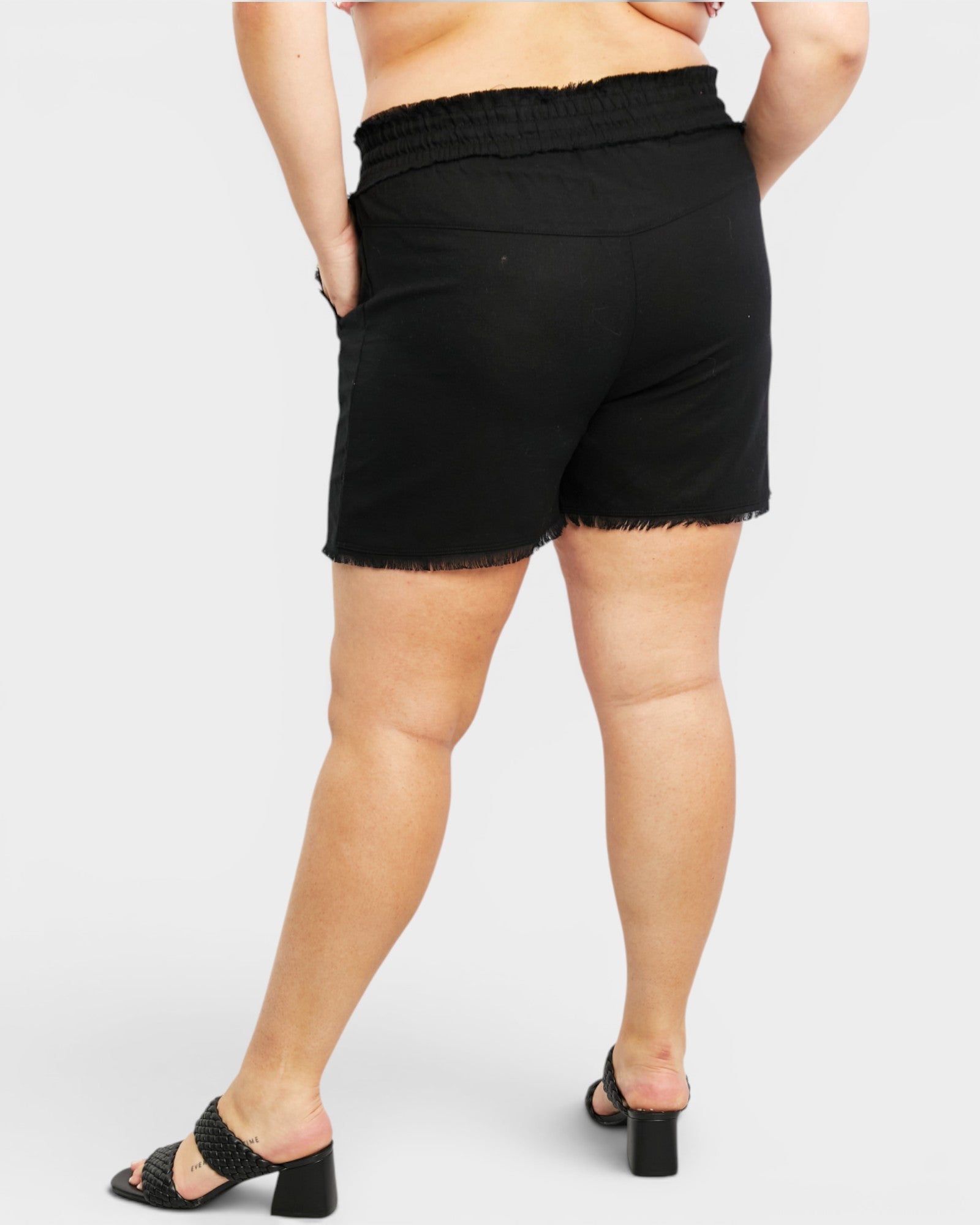 Person wearing black shorts on a white background