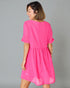 Woman wearing a bright pink dress against a gray background