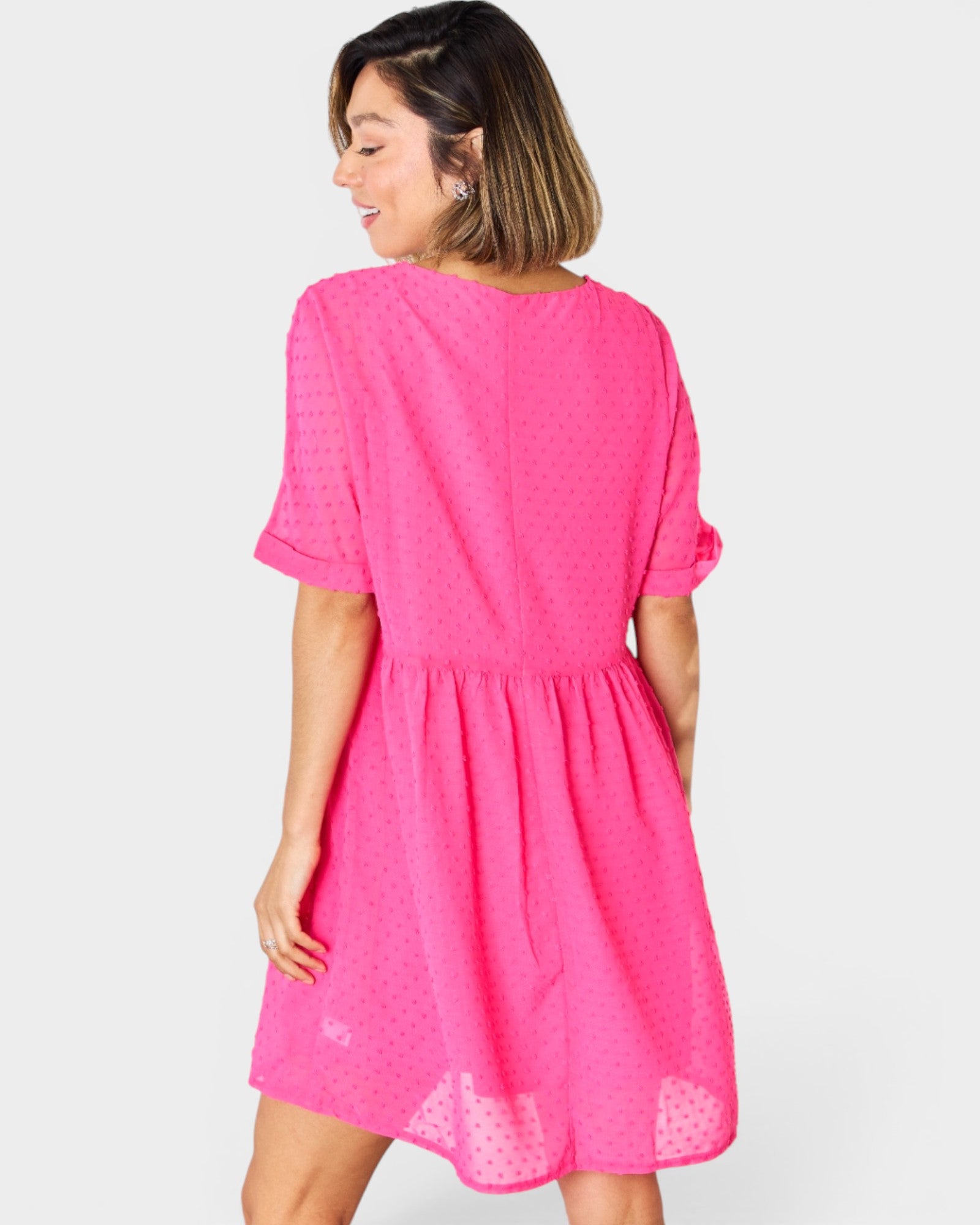 Woman wearing a bright pink dress on a white background