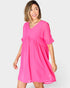 Woman wearing a bright pink dress on a white background