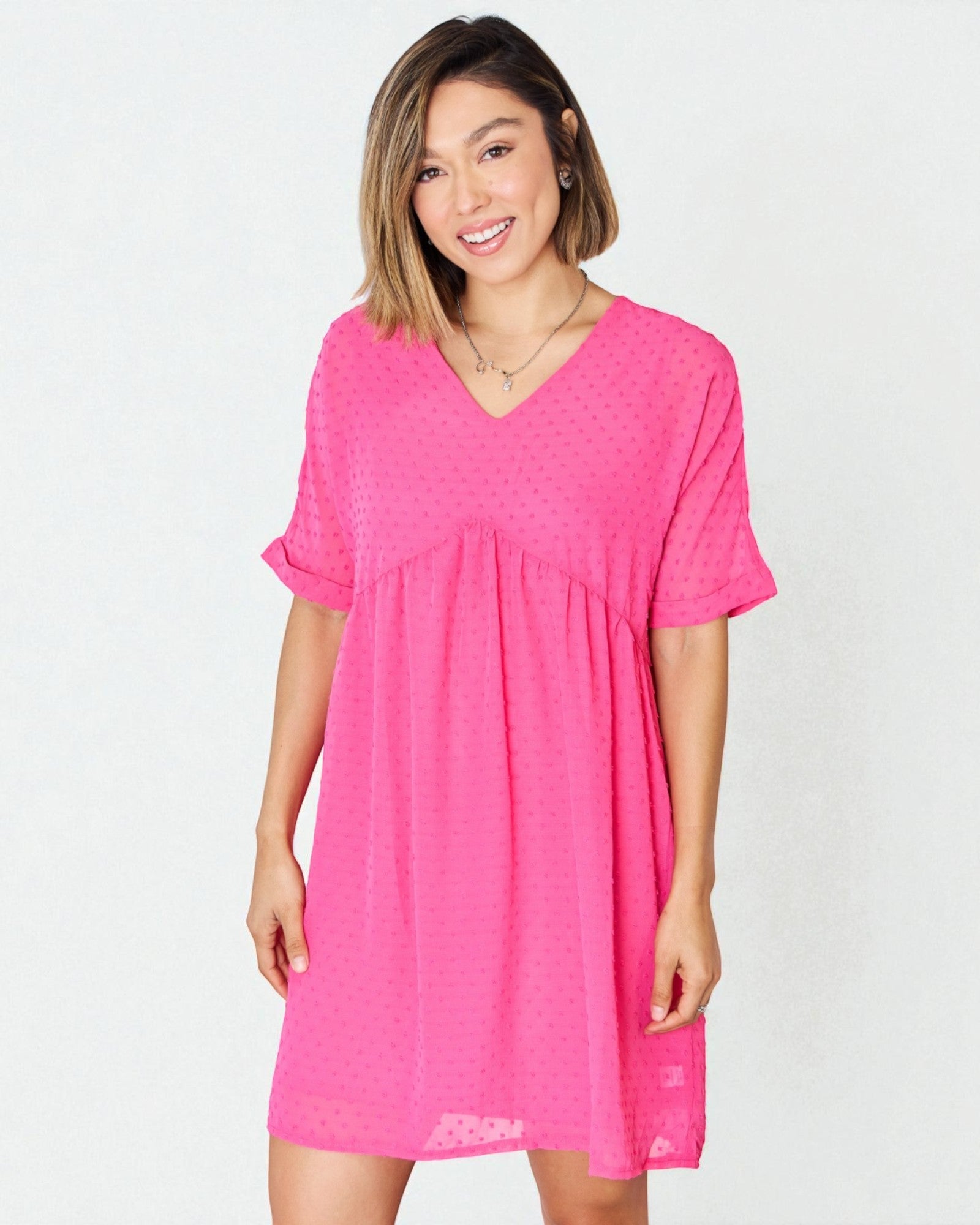 Woman wearing a bright pink dress on a white background