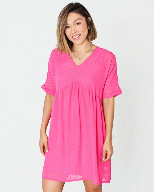 Woman wearing a bright pink dress on a white background