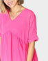 Woman wearing a bright pink dress with a plain background