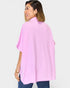 Woman wearing a pink poncho against a white background