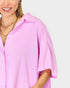 Person wearing a pink shirt with a plain background