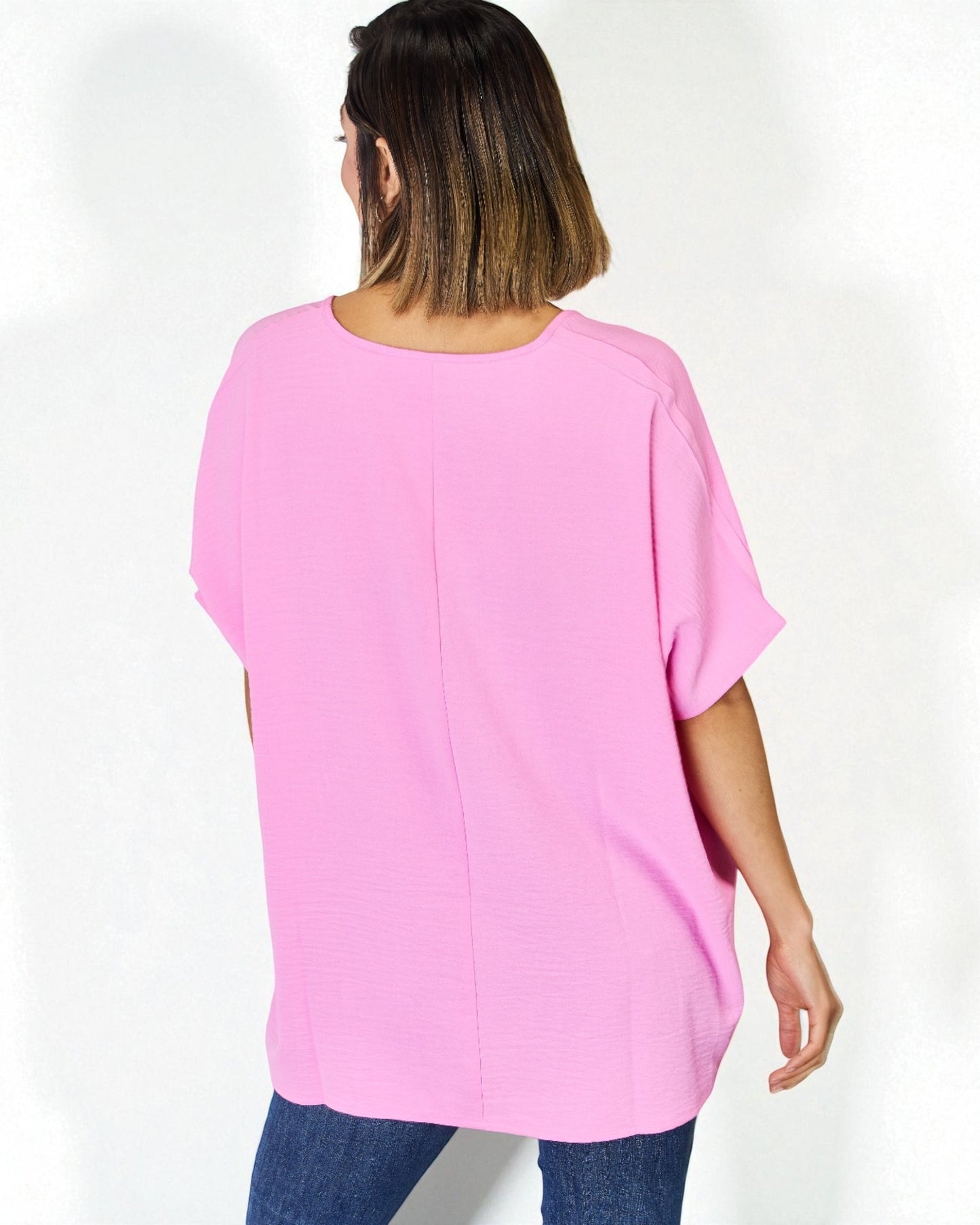 Person wearing a pink oversized top on a white background