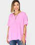 Woman wearing a pink oversized shirt and blue jeans on a white background