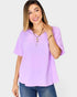 Woman wearing a light purple blouse and blue jeans on a white background