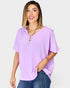 Woman wearing a light purple top and blue jeans on a white background