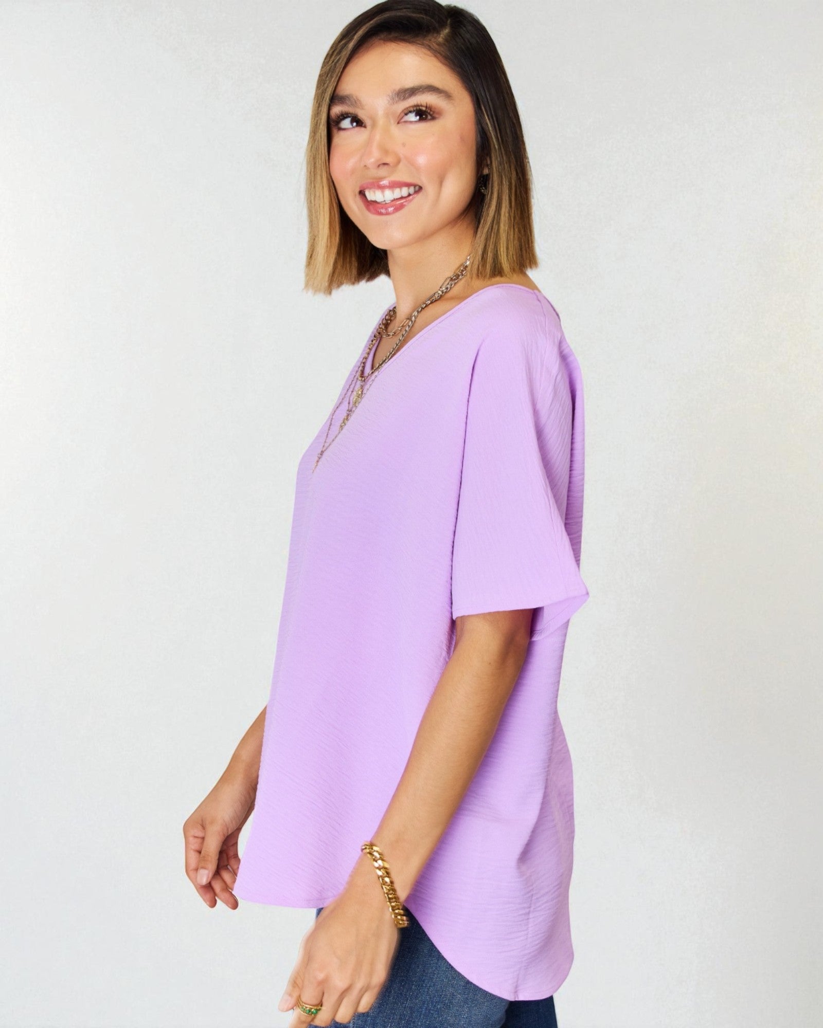 Woman wearing a light purple blouse against a white background