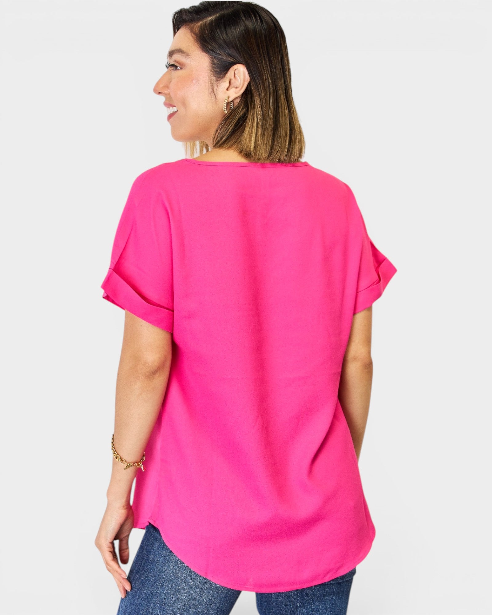 Woman wearing a bright pink oversized shirt on a white background