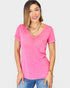 Woman wearing a pink V-neck t-shirt and blue jeans on a white background