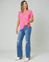 Woman wearing a pink top and blue jeans on a plain background