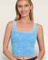 Woman wearing a blue tank top against a plain background